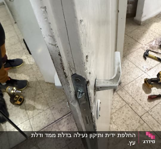 תמונה של דלת עם מנעול וכלי עבודה על הרצפה